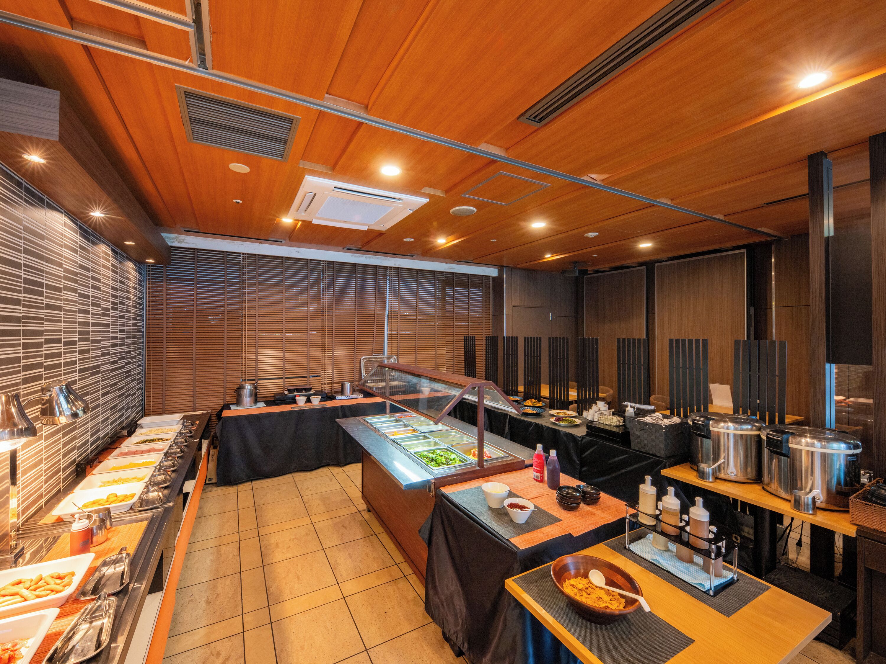 Un buffet proposant une variété de plats, un coin café et un espace détente avec des tables et des chaises.