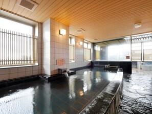 A traditional Japanese onsen with a wooden ceiling, tiled walls, and a stone floor. - APA Hotel Nagoya Sakae (Nagoya)