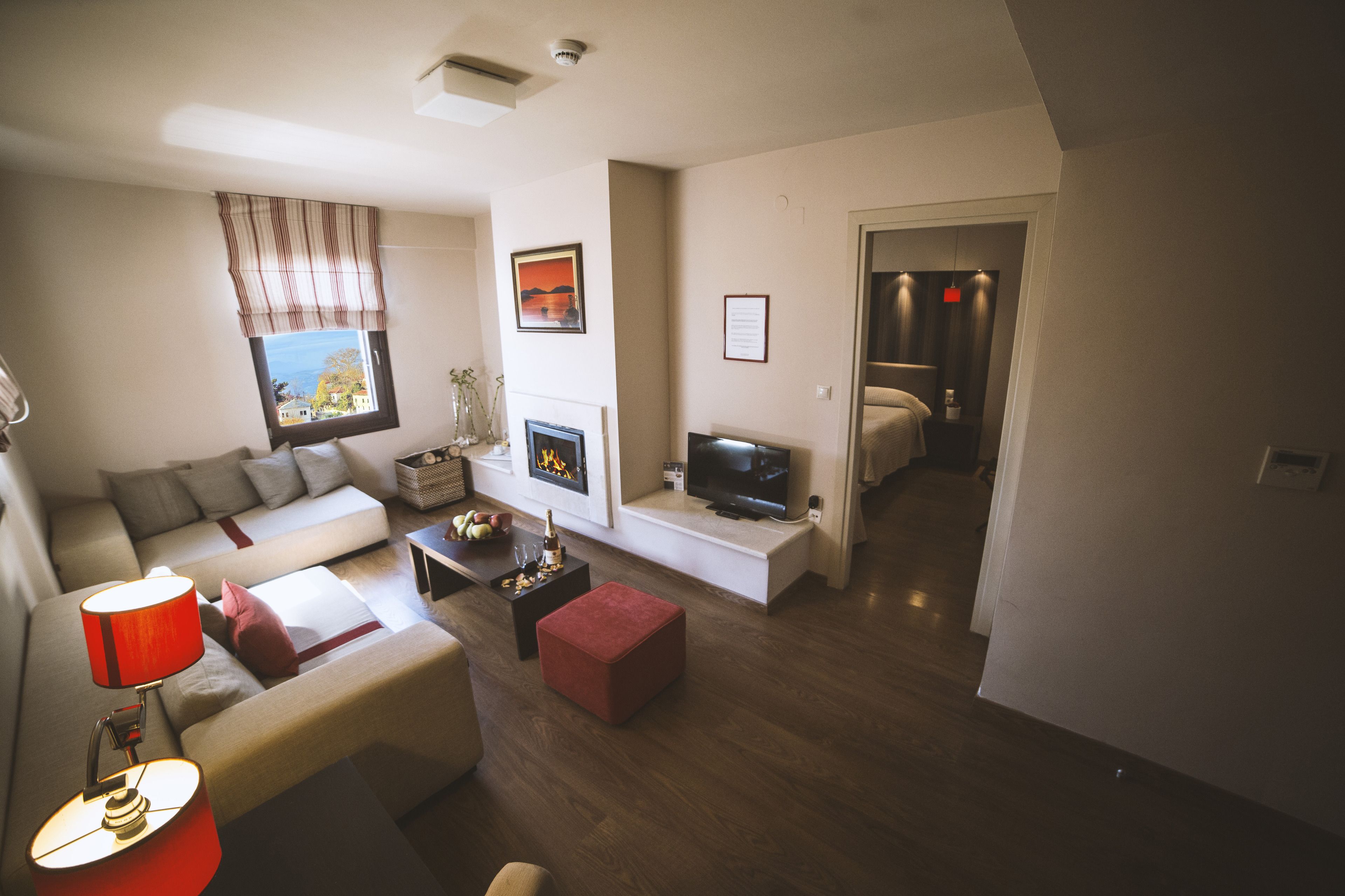 Una sala moderna con sofá, reposapiés y televisor sobre un mueble.