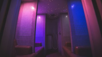 Experience the unique tile design and enjoy a shower with handheld showerhead and wall-mounted faucet, plus a cozy seating area.