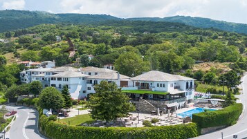 A hotel with multiple buildings, a swimming pool, and a landscaped garden.