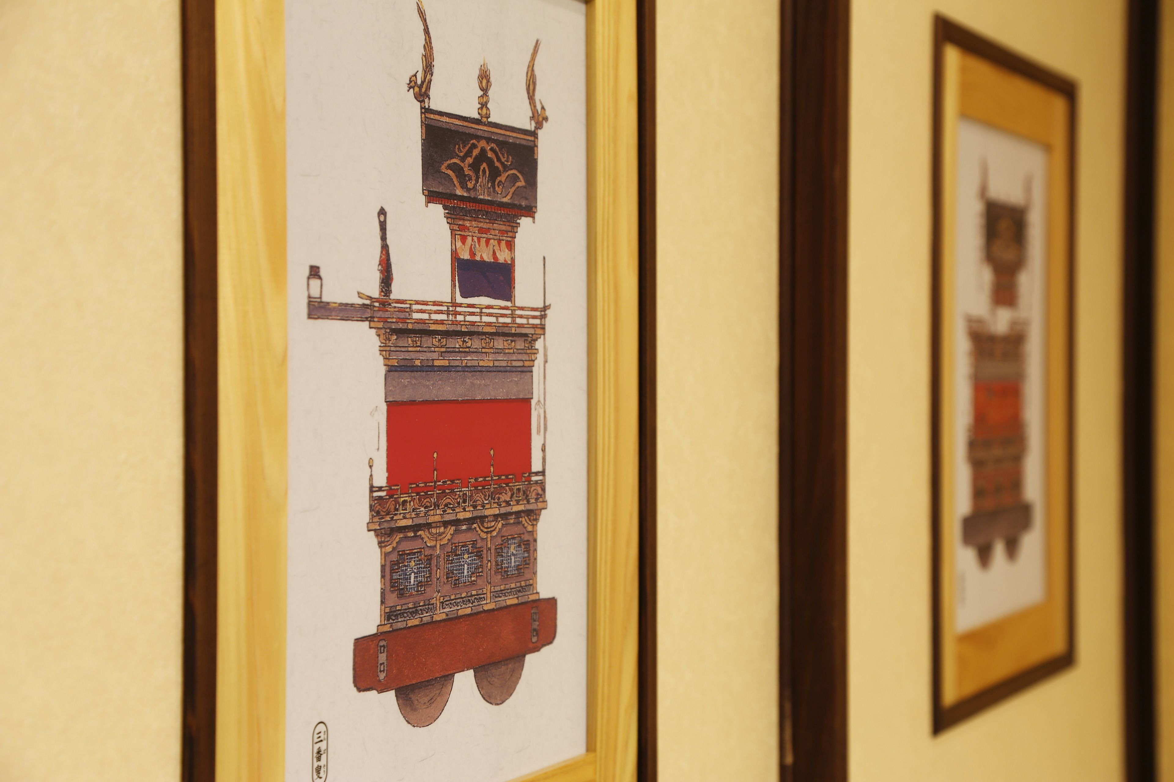 A framed artwork of a traditional structure with intricate designs and a flag.