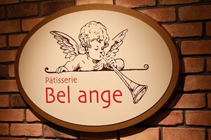 A sign with a cherub illustration and the text "Pâtisserie Bel ange".