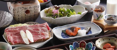 Verschiedene Gerichte und Schüsseln auf einem Tisch, darunter Sushi, Gemüse und andere asiatische Spezialitäten.