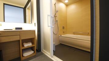 A modern bathroom with a wooden vanity, a large mirror, a shower with a handheld showerhead, and a bathtub.