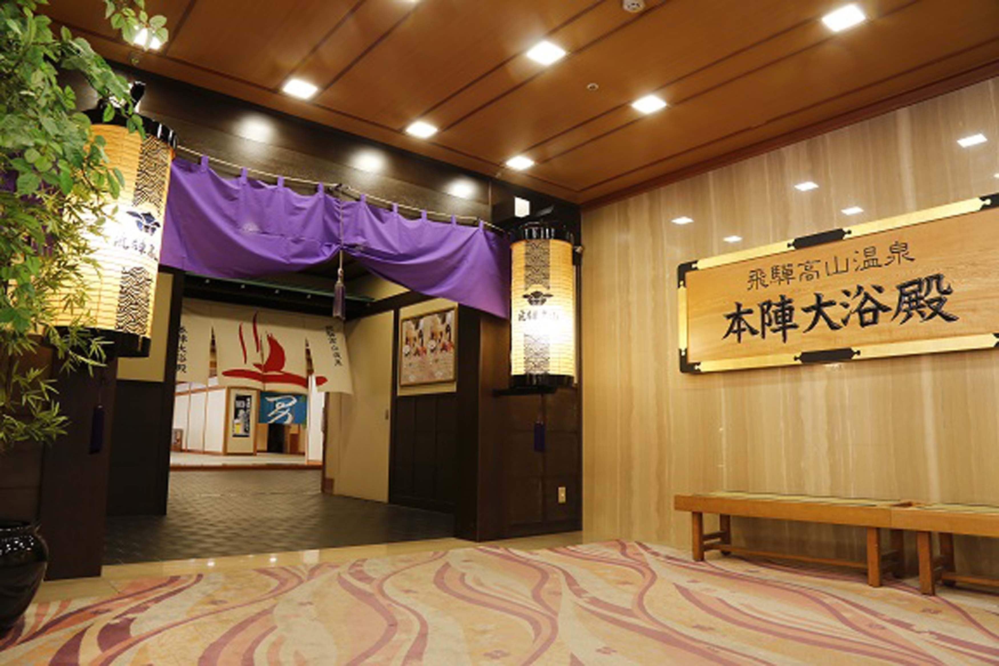 A traditional Japanese interior with tatami flooring, a wooden bench, and a sign with Japanese characters.