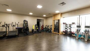 Ett gym med löpband, crosstrainers och utrustning för styrketräning.