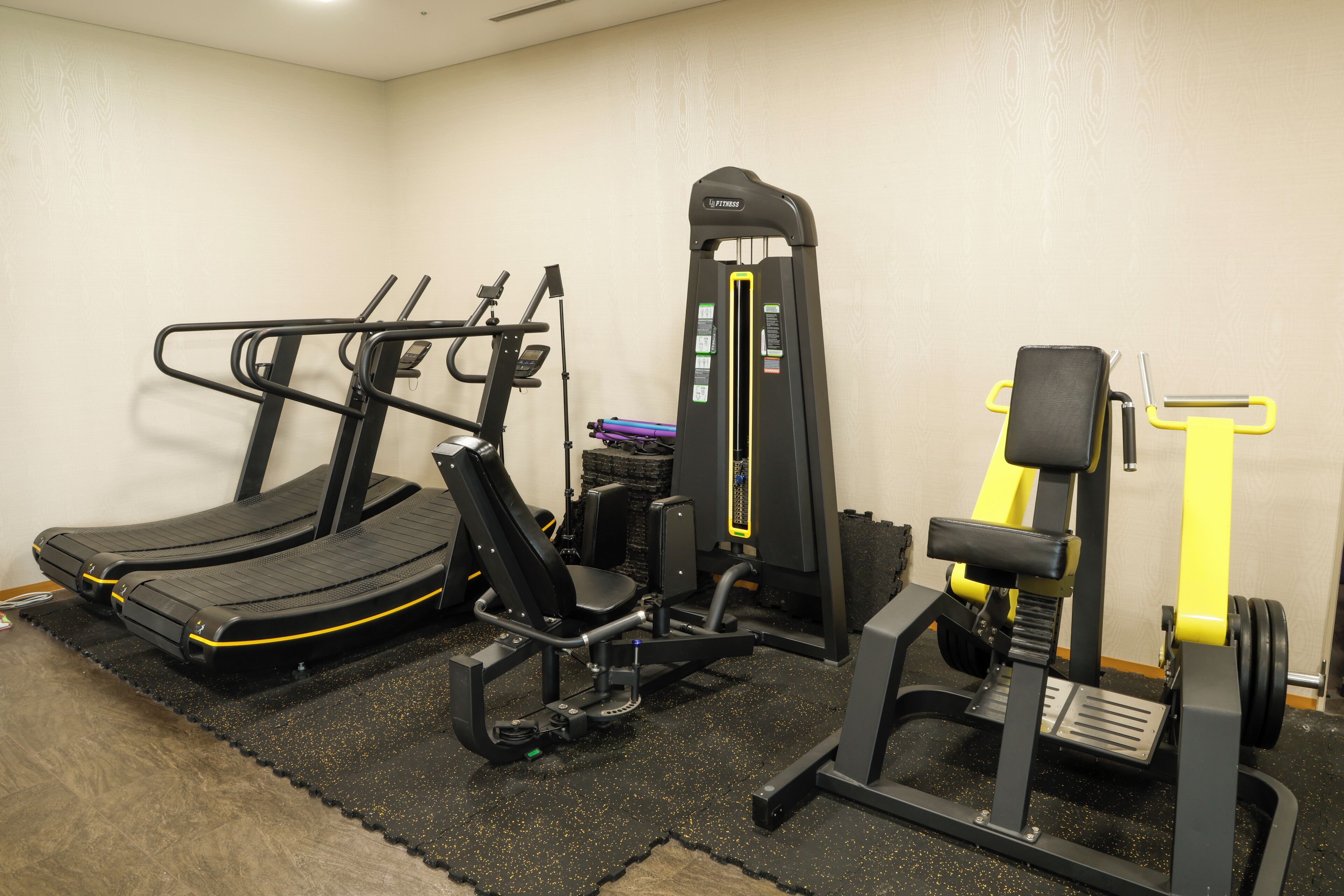 A gym with treadmills, a weight machine, and a bench press.