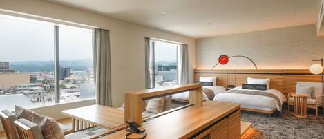 A modern hotel room with a large bed, a desk, and a view of the city.