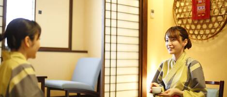 A traditional Japanese room with tatami flooring, a low table, and a shoji screen.