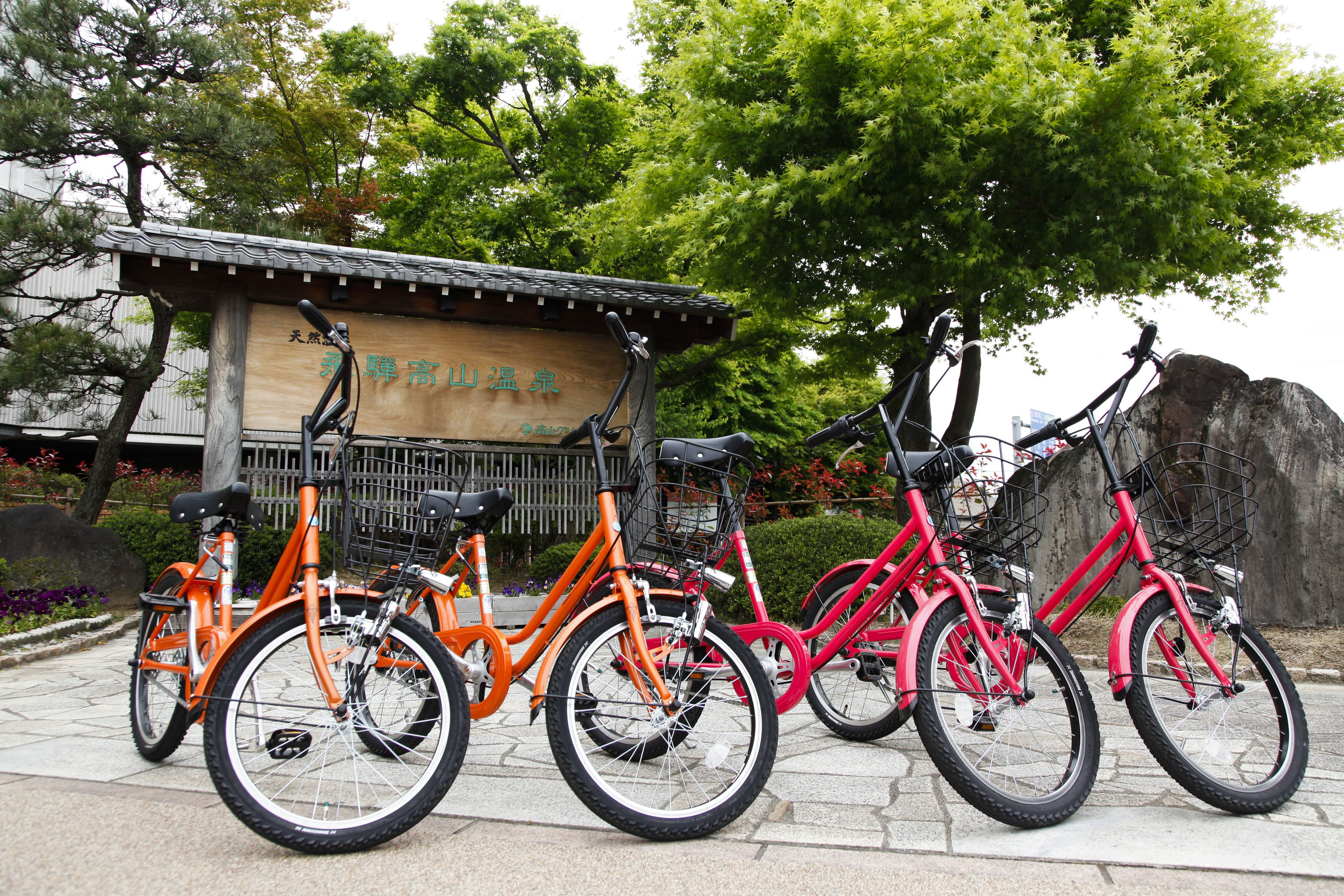 A row of bicycles parked in front of a building with a sign.