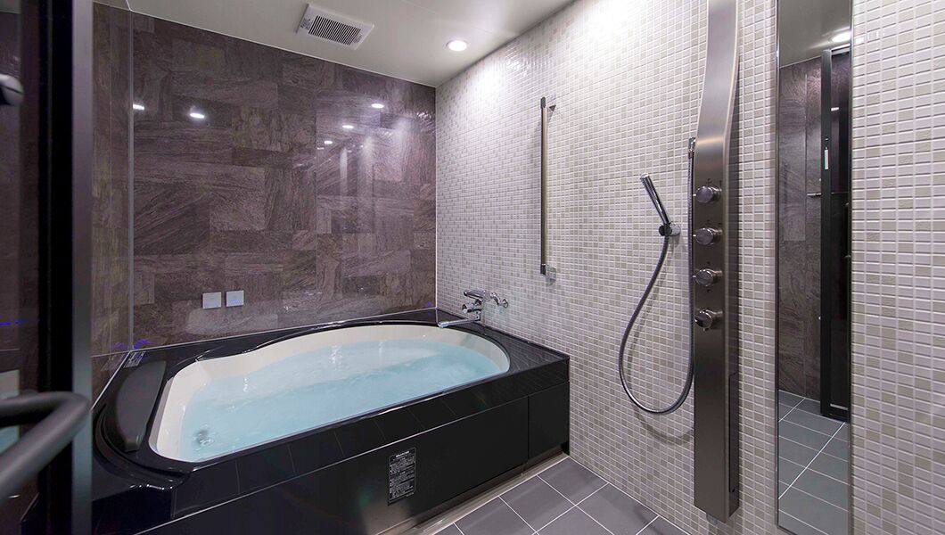 A modern bathroom with a freestanding bathtub, a walk-in shower, and tiled walls.
