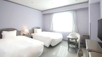 A hotel room with two beds, a desk, a chair, a TV, and a window with curtains.