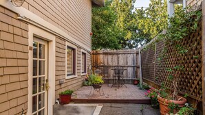 A backyard with a wooden fence, a patio with a table and chairs, and potted plants. - Hotel Napa Valley, an Ascend Collection Hotel (Napa)