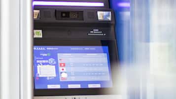 A foreign currency exchange machine with a digital display and multiple currency options.