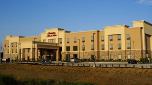 A hotel with a prominent 'Jim Dine' sign, multiple windows, and a parking area in front.