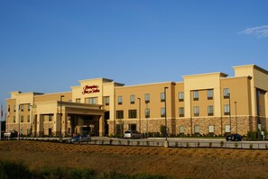 A hotel with a prominent 'Jim Dine' sign, multiple windows, and a parking area in front.