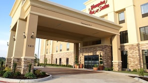 A Hampton Inn Suites building with a beige facade, stone accents, and a clear sky. - Hampton Inn & Suites Center (Center)