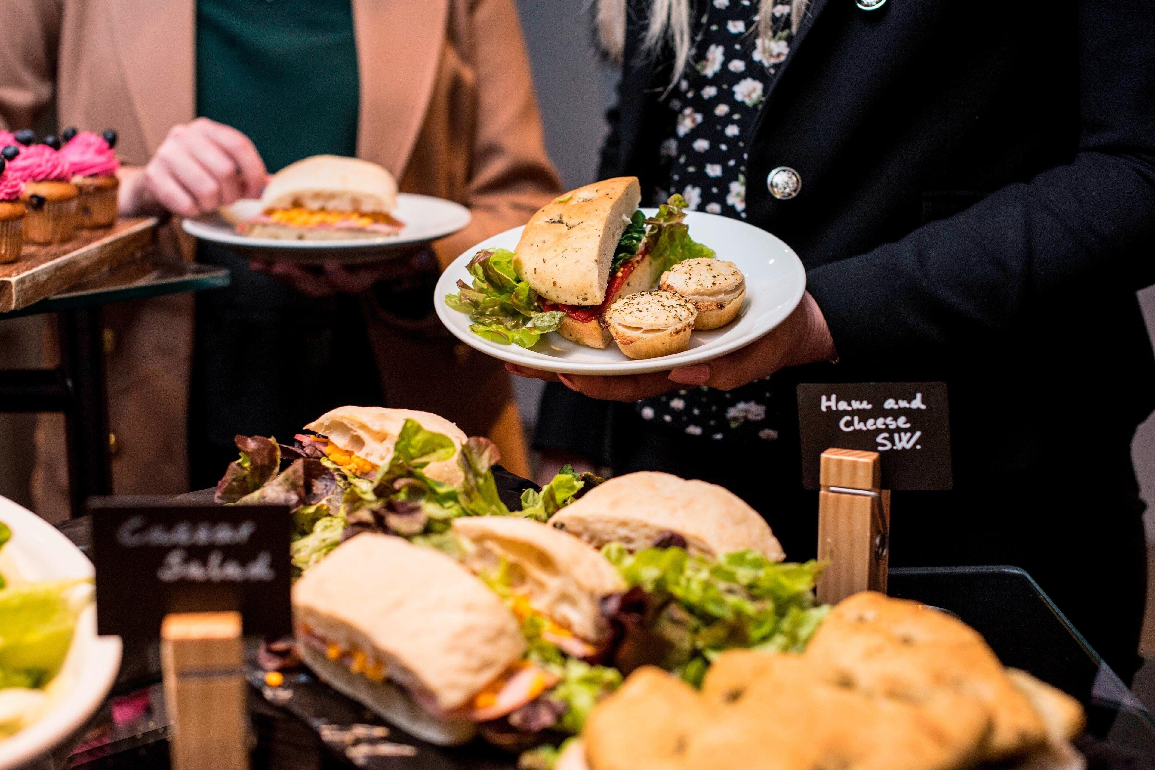 A food display with sandwiches and a sign indicating 'Ham and Cheese S.W.'