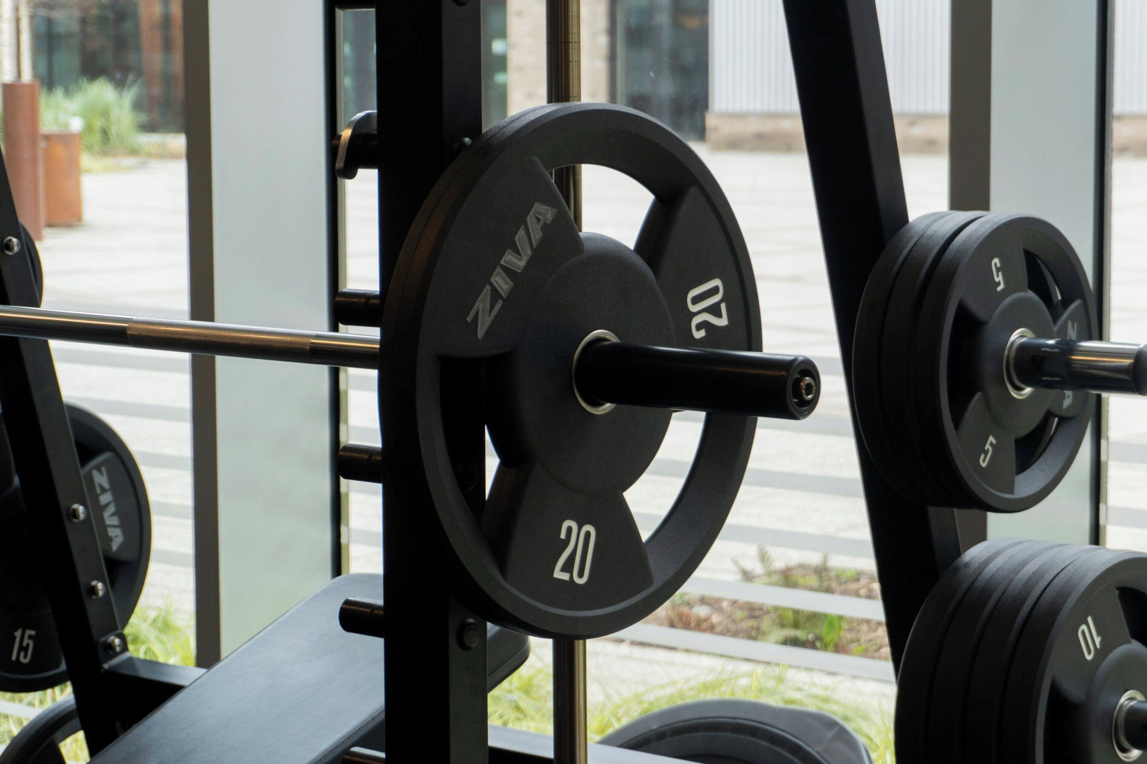 A weightlifting area with barbells and weight plates, including a 20 kg and a 15 kg plate.