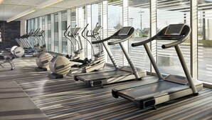 A modern gym with treadmills, elliptical machines, and stationary bikes.