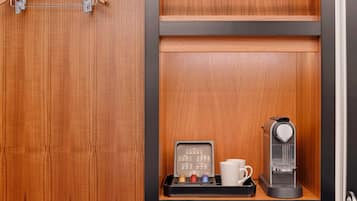 A wooden cabinet with a coffee machine and a tray of coffee pods.