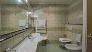 Ein Badezimmer mit zwei Waschbecken, einer Toilette und einem Bidet.