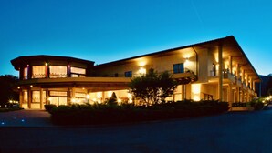Un hotel de varios pisos con patio central, ventanas amplias y techo plano.