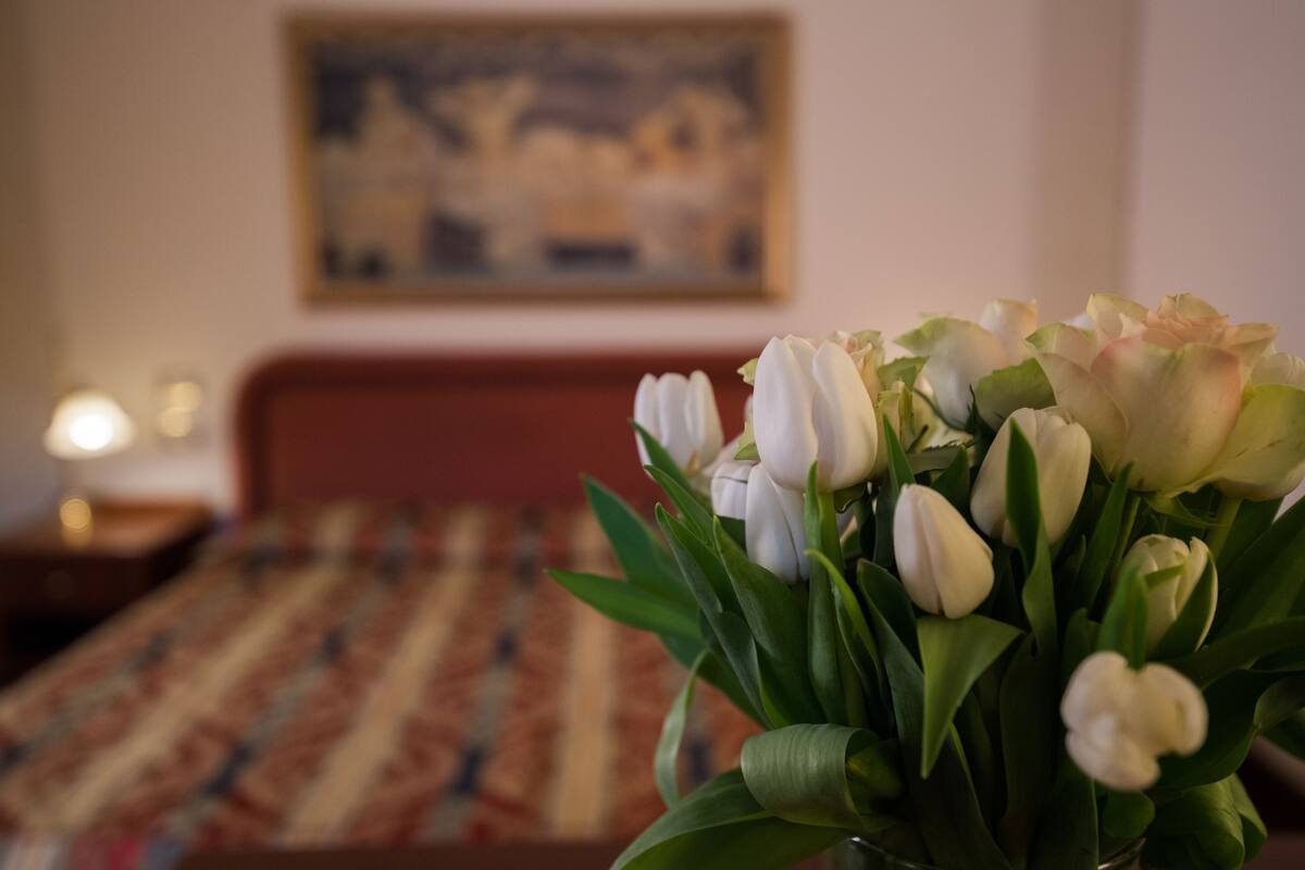 A bed with a striped bedspread and a painting on the wall.