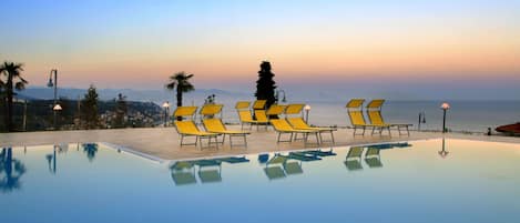 Piscine extérieure, parasols de plage, chaises longues