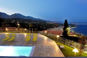A pool area with lounge chairs and a view of the sea and mountains. - Residence Villa Beuca (Cogoleto)