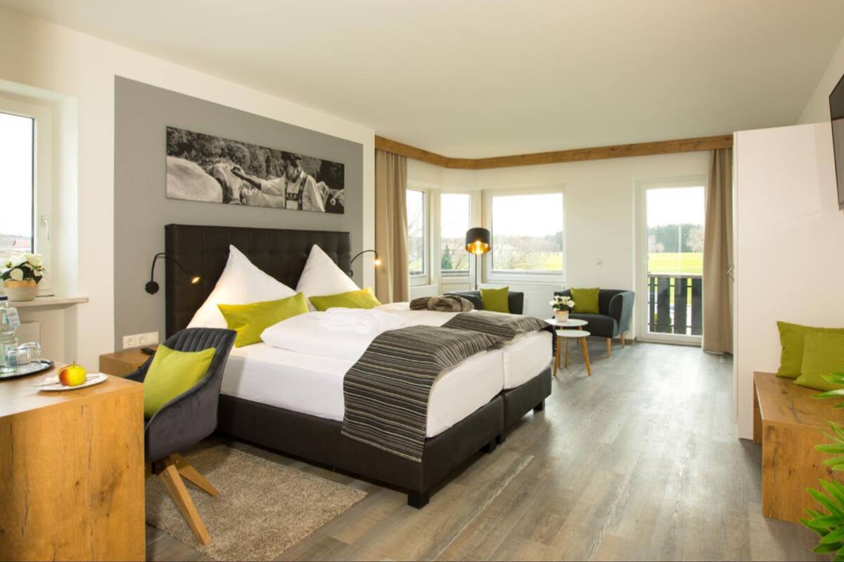 Une chambre d’hôtel moderne dotée d’un grand lit, d’un coin salon et d’un balcon.