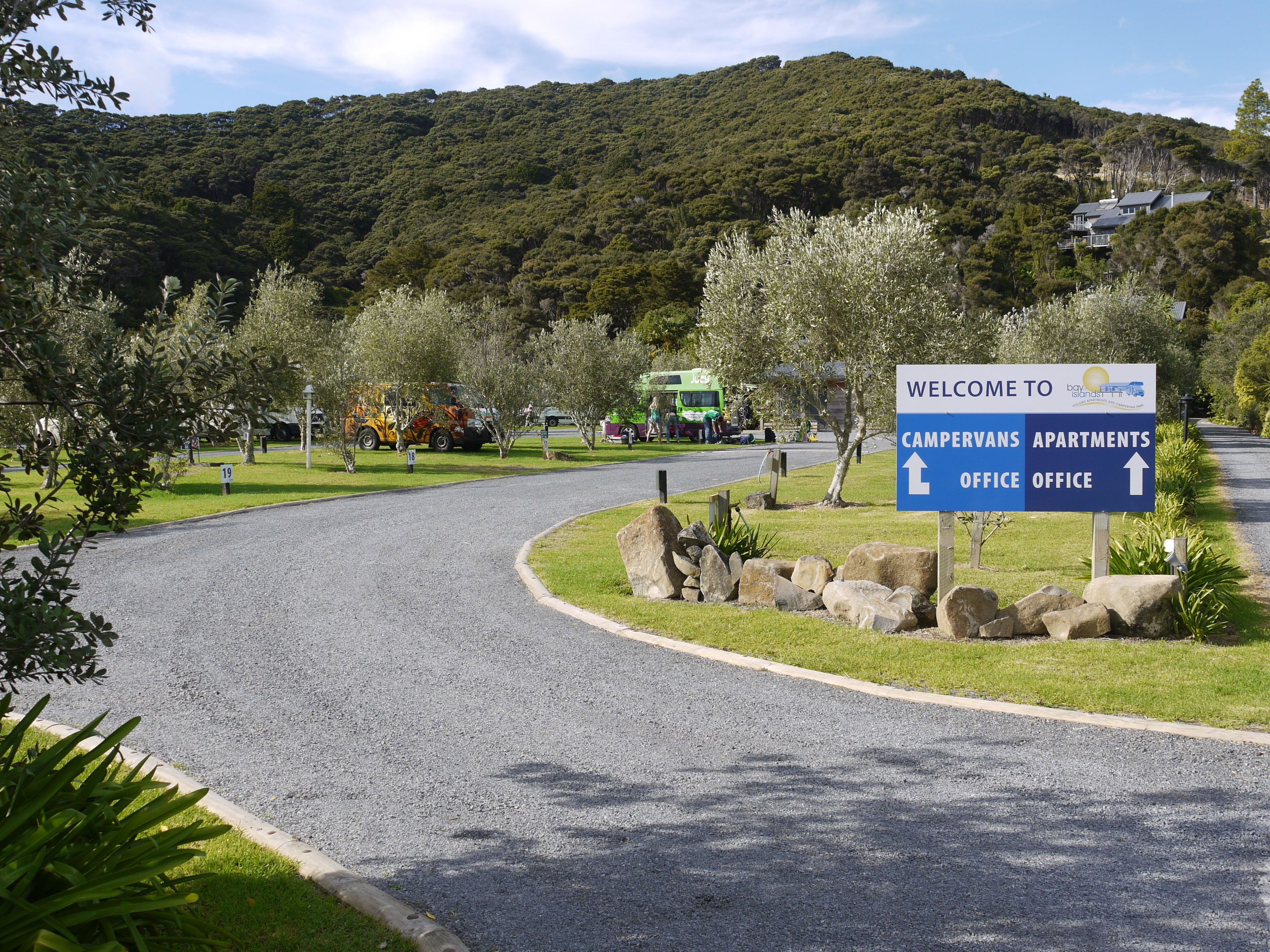 A welcome sign for Bay of Islands, indicating directions to campvans, apartments, and office areas.