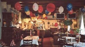 A restaurant interior with tables set for dining, balloons hanging from the ceiling, and various decorations. - Schlossberg (Heppenheim)