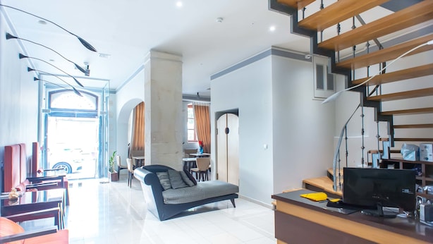 Un amplio espacio de sala con un sofá, una mesa de comedor y una escalera.