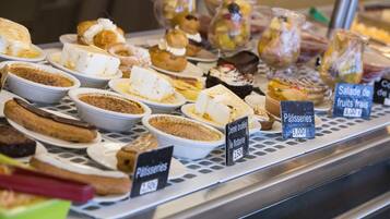 A display of various pastries and desserts in a bakery setting.