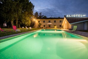 A swimming pool with lounge chairs and a building labeled "ALIOTEL" in the background. - Hotel Aliotel (Cazeres-sur-l'Adour)