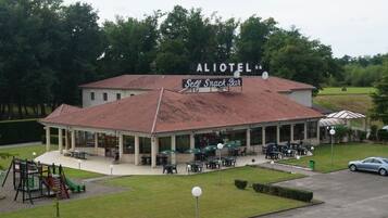 An ALOIOTEL with a self-service snack bar, outdoor seating, and a playground.