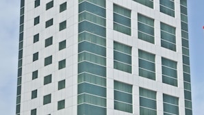 A modern high-rise building with a grid of windows and a white facade. - Ramee Royal Hotel Apartments (Abu Dhabi)