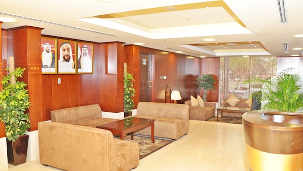 A lobby with plush seating, framed portraits on the wall, and potted plants. - Ramee Royal Hotel Apartments (Abu Dhabi)