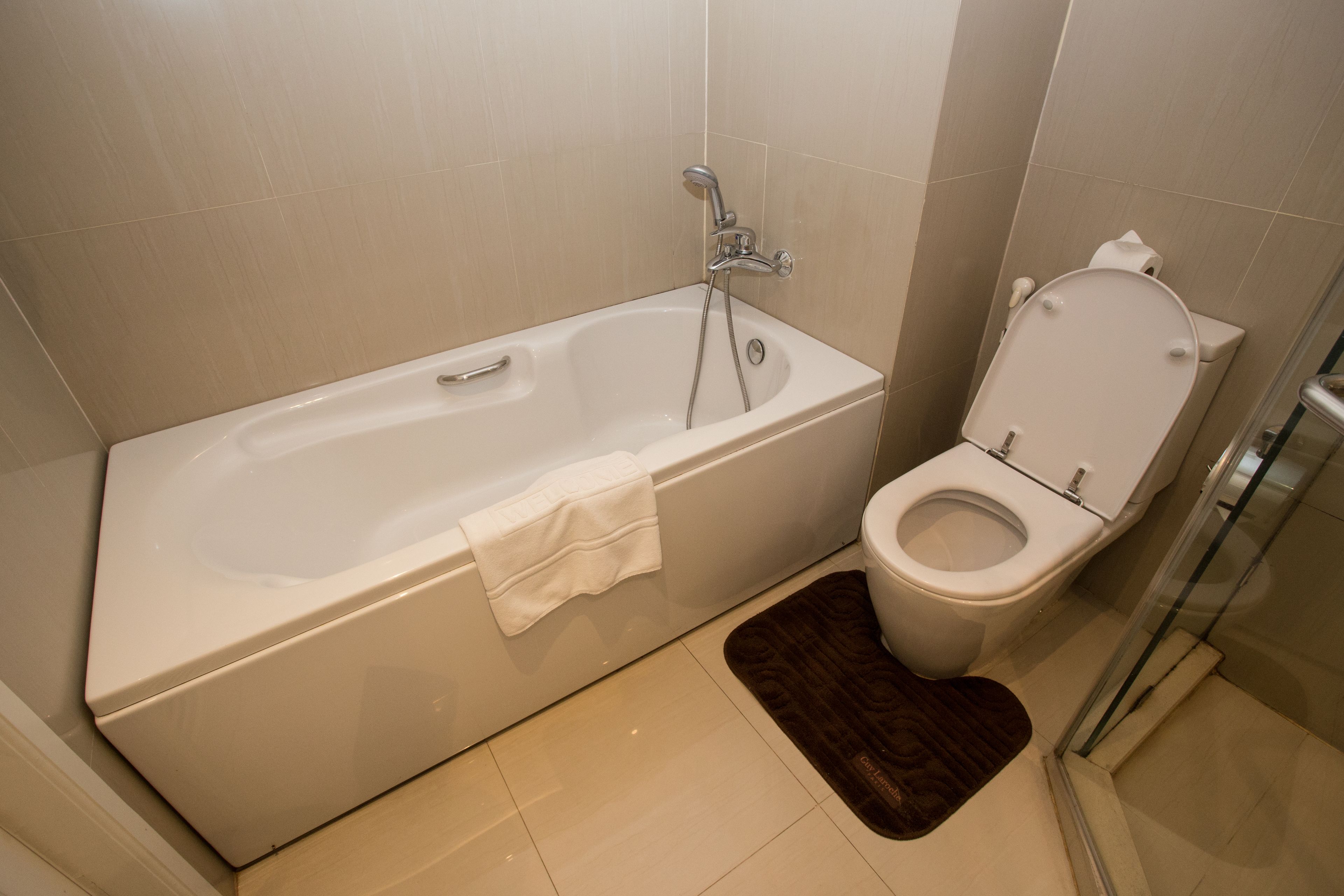 Un baño con bañera, inodoro y cabina de ducha de vidrio.