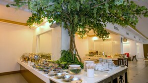 Ein Buffet mit verschiedenen Speisebehältern und einem dekorativen Baum.