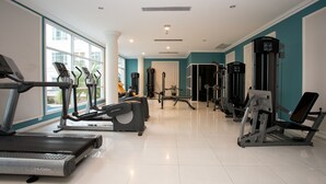Ein Fitnessstudio mit Laufbändern, Crosstrainern und Gewichten.