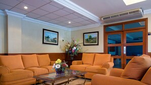 Rebedor d'hotel amb dos sofàs, una taula de cafè i un arranjament floral.