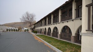 A building with a row of arched windows and a covered walkway. - Quality Inn Baker City (Baker City)