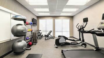 A gym with treadmills, elliptical machines, and weightlifting equipment.