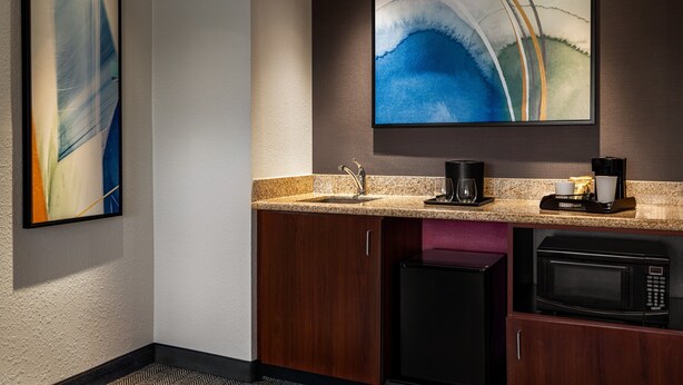 A modern kitchen with a granite countertop, a coffee maker, a microwave, and a sink. - Courtyard by Marriott Burlington Mt. Holly Westampton (Mount Holly)