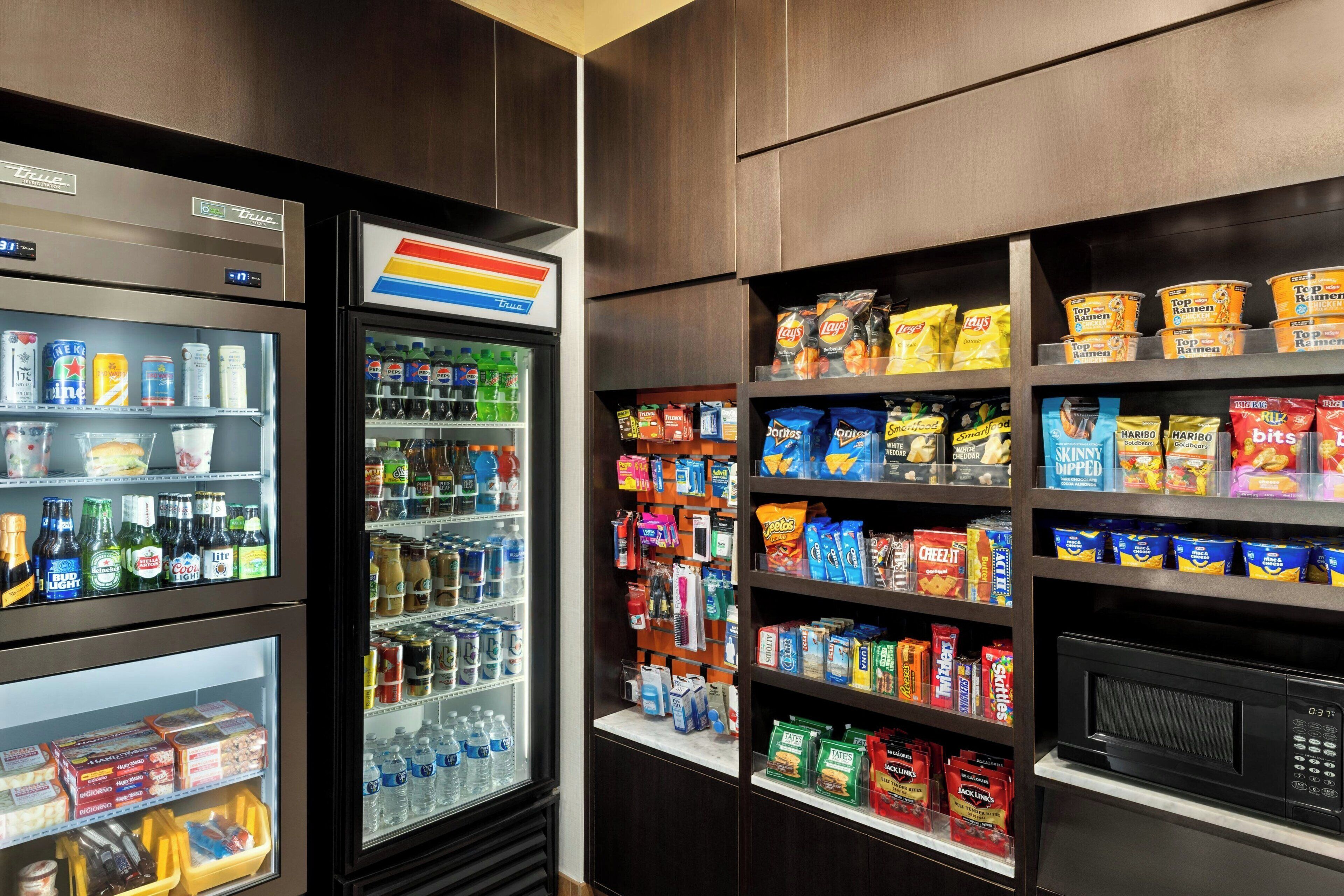 A convenience store with refrigerated sections, snack aisles, and a microwave.