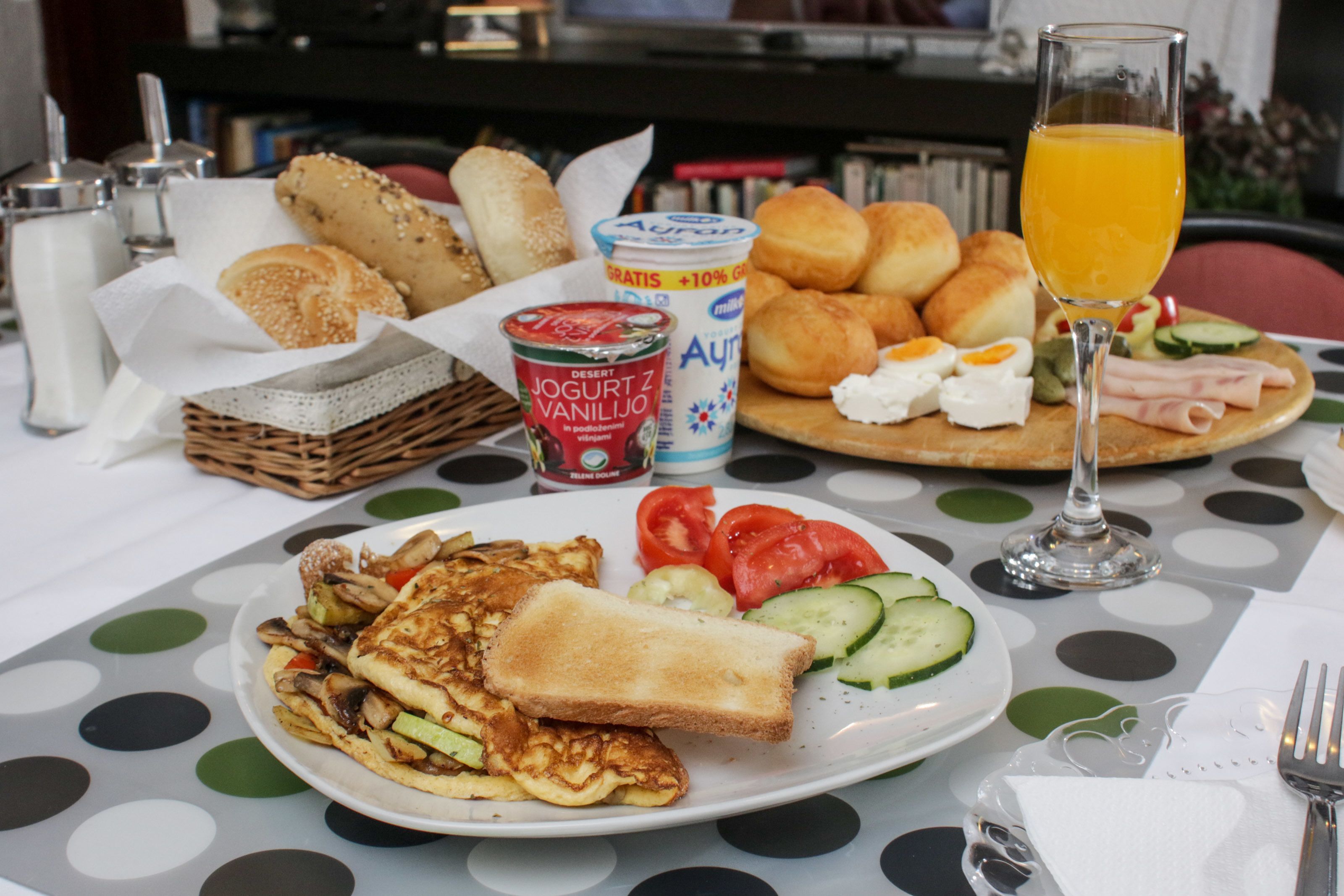A breakfast table with various food items, including toast, eggs, and vegetables.