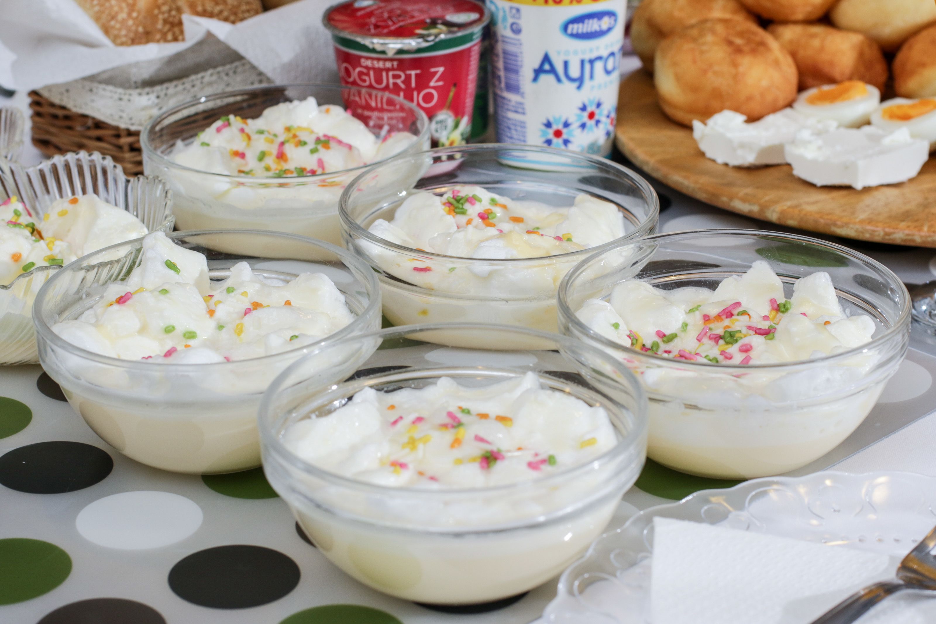 Des coupes de dessert décorées de vermicelles, un pot de yaourt et une assiette de pain.